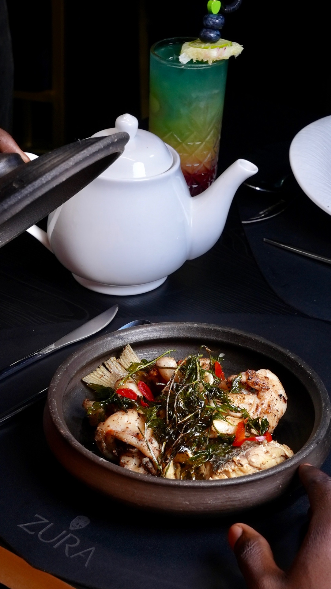 An herb-topped ZURA grill dish served at the table